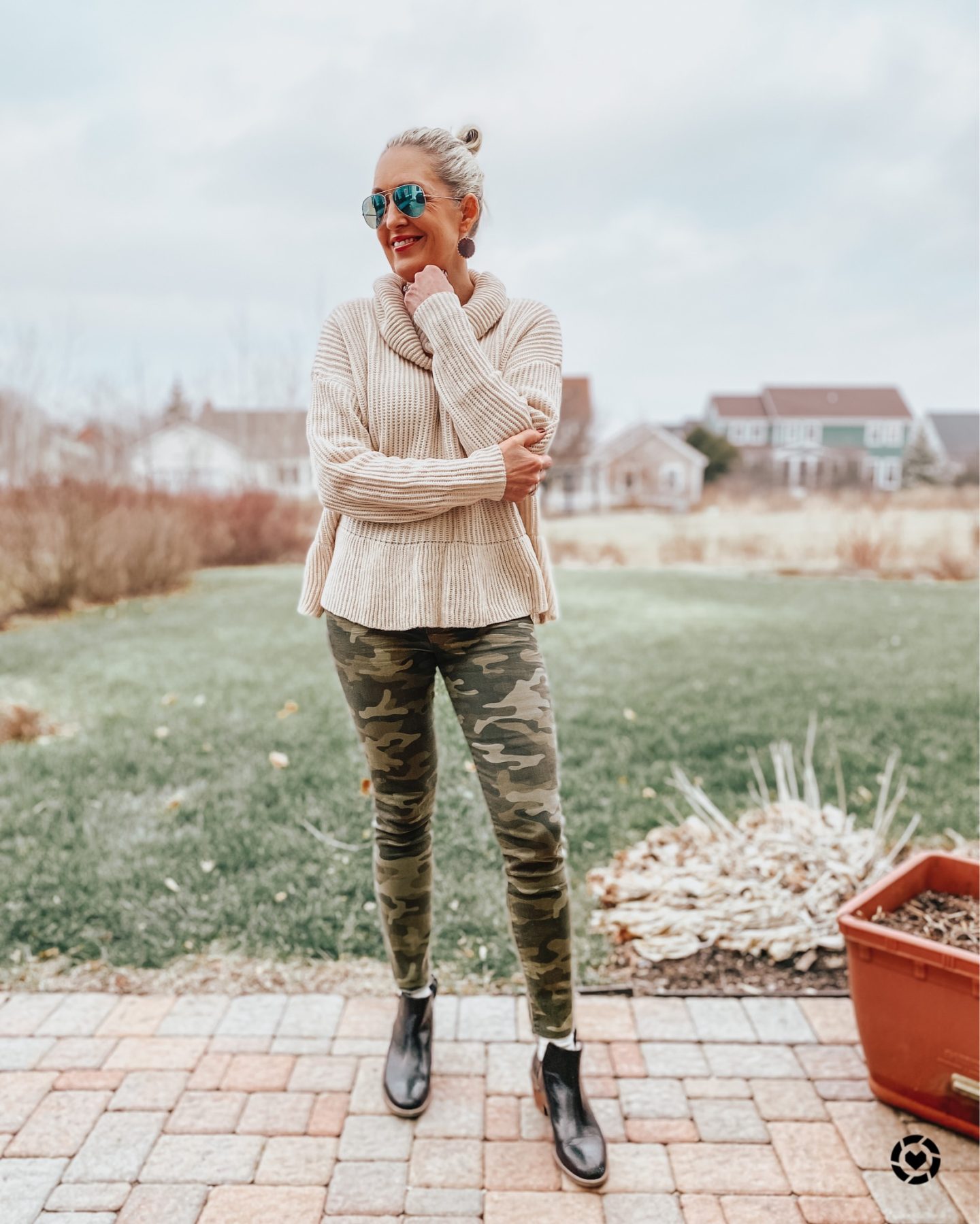 taupe peplum sweater worn with camo skinny jeans and booties