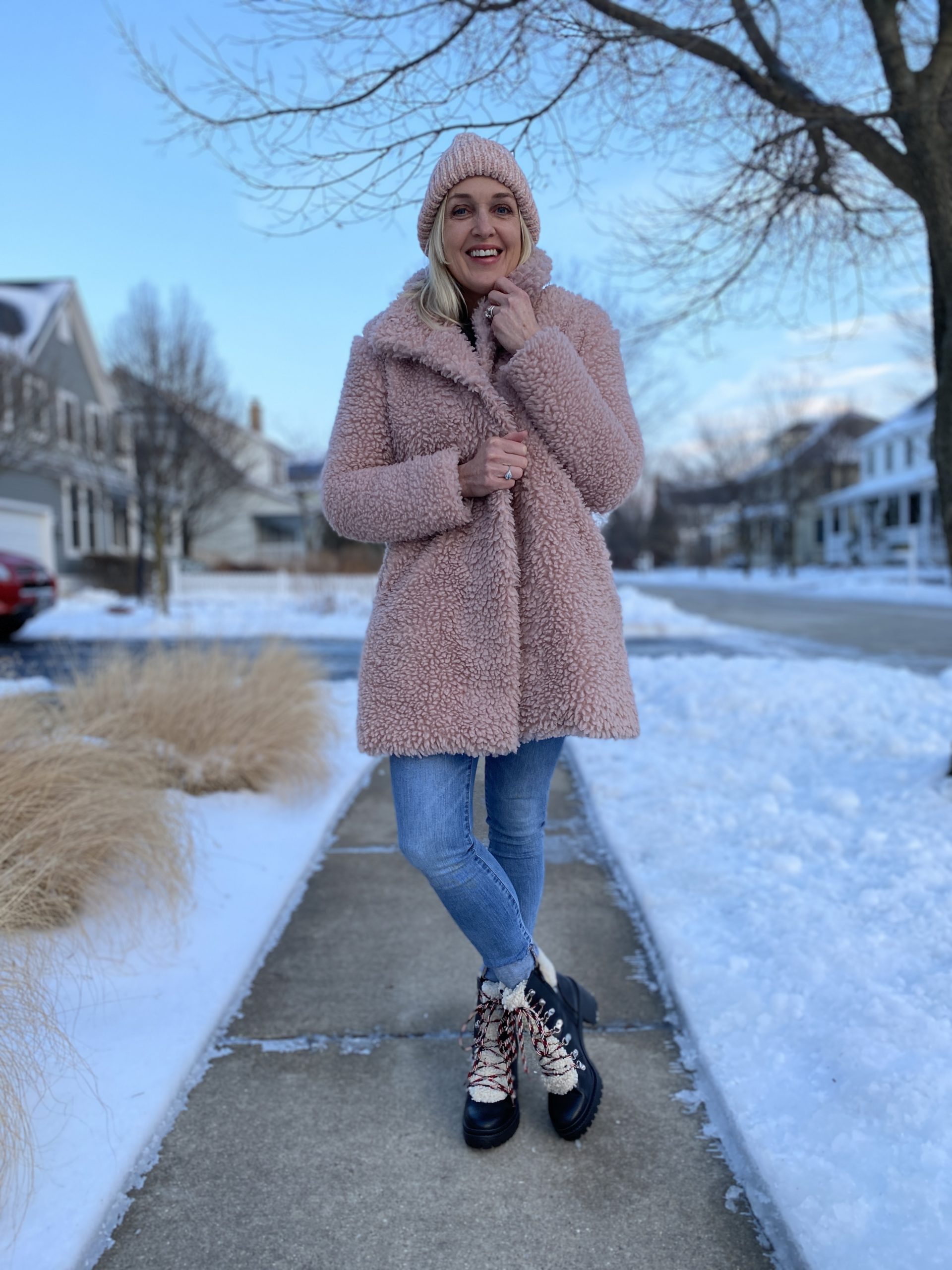 pink teddy coat worn with a pink beanie, jeans and sherpa lace-up booties.