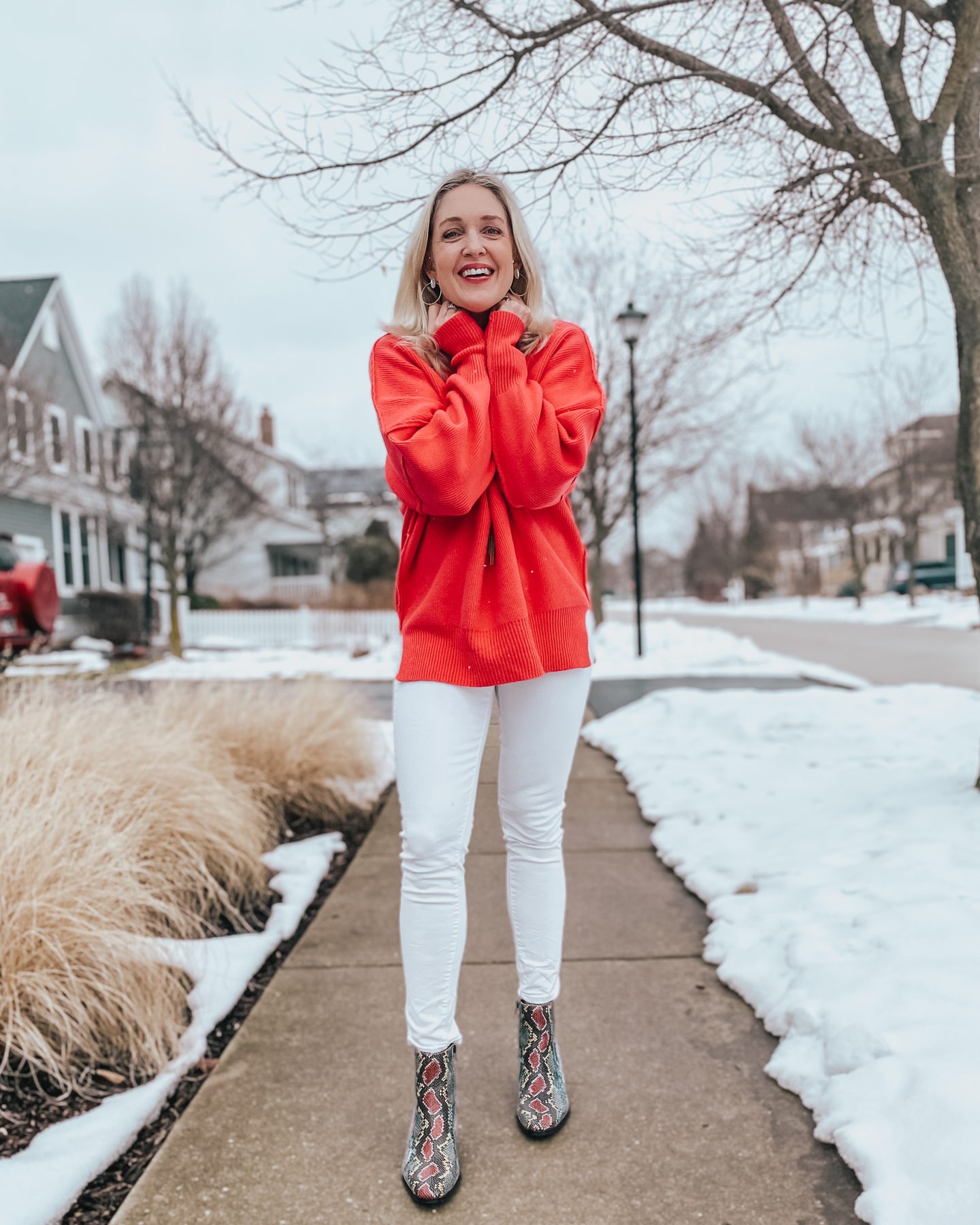 bright pink oversized sweater worn with white denim and snakeprint booties.