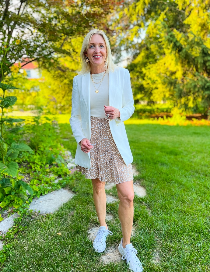 woman wearing printed skirt, beige tank top and white blazer