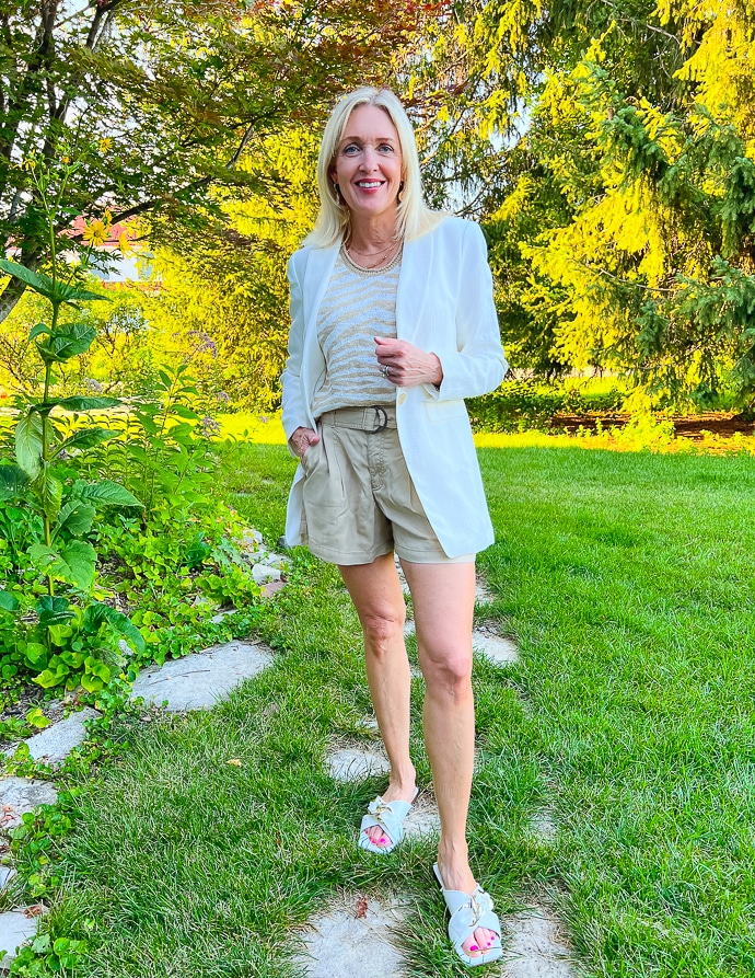 woman wearing beige tiger print top, belted shorts and white blazer