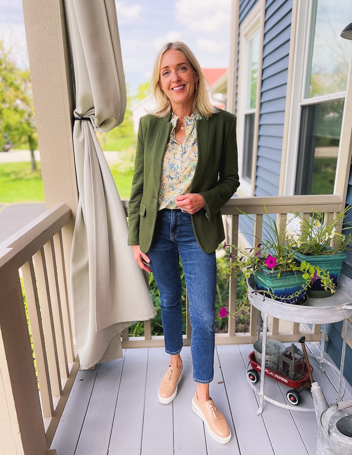 woman wearing olive green blazer with dark wash denim